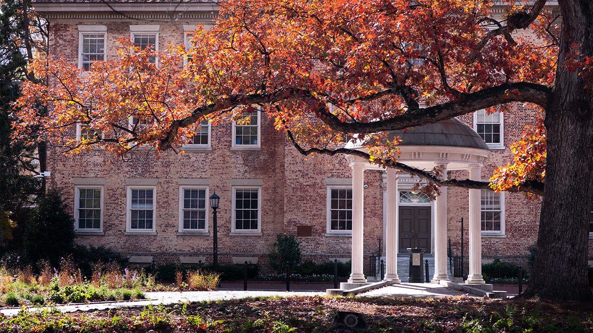 Exterior image of the Old Well in the fall, partially obscured by a tree branch.